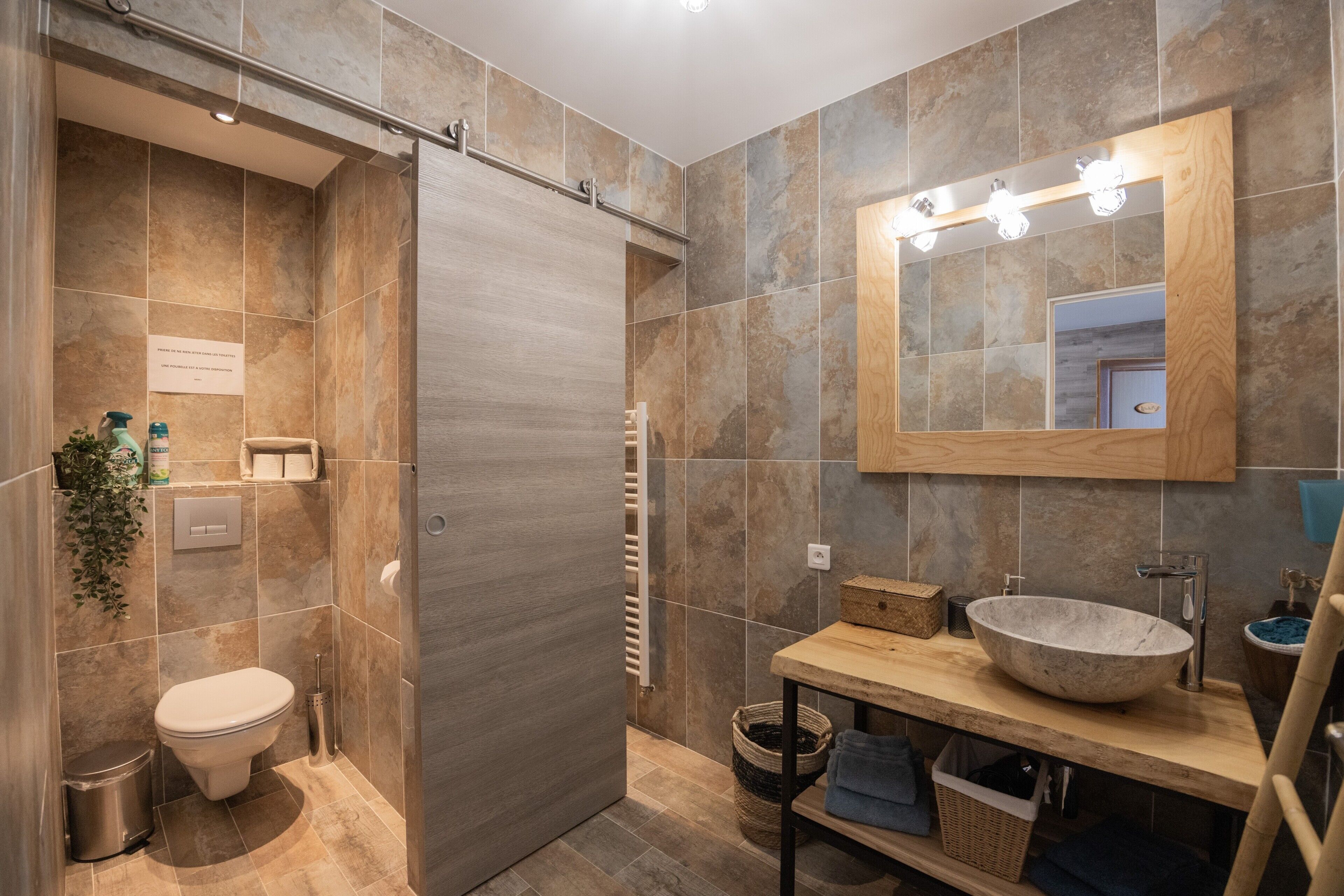 Une salle de bain moderne équipée d’une douche, de toilettes, d’un lavabo et d’un grand miroir.
