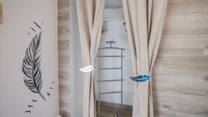 Ein Zimmer mit Holzboden, einer Metallleiter und einer Wand mit Feder- und Vogelillustrationen.