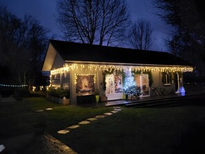 A house with a porch decorated with lights and a Christmas tree. - “Chambre Raphaël” Guest Room with Mountain View, Wi-Fi, and Air Conditioning (Singles)