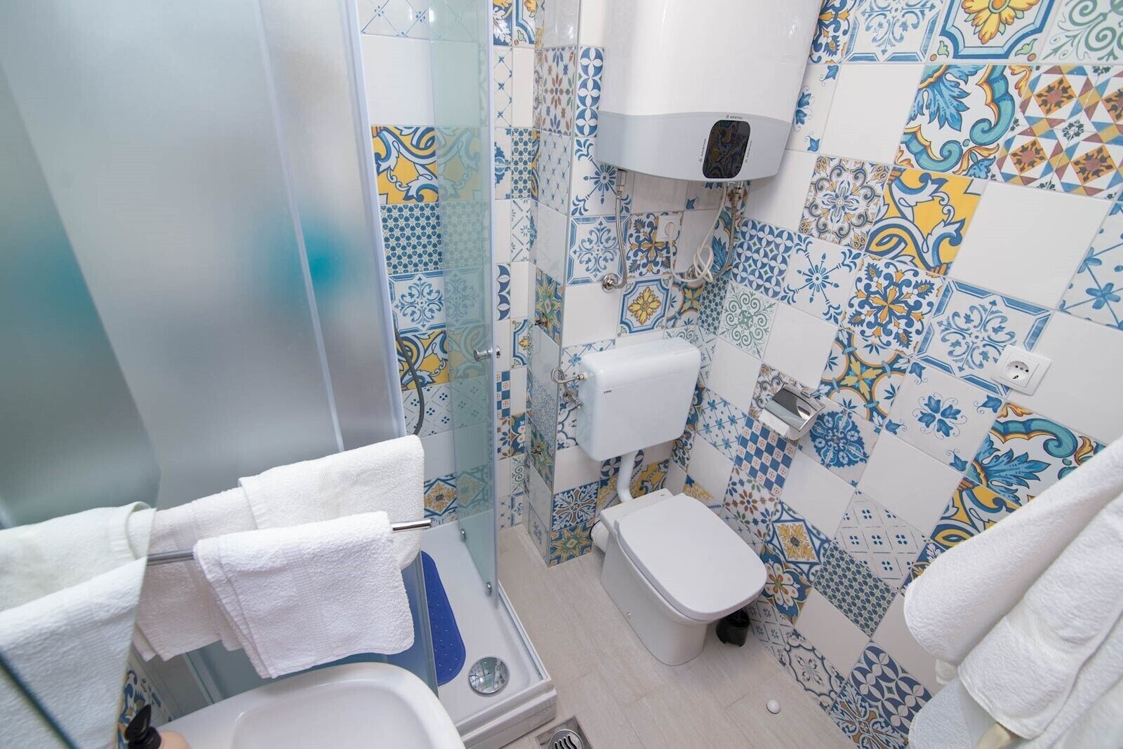 A bathroom with a shower, toilet, and sink.