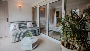 Un salon moderne avec un canapé, une table basse ronde et une grande plante en pot.