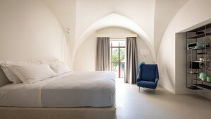 Un dormitorio con cama, una silla y una estantería.