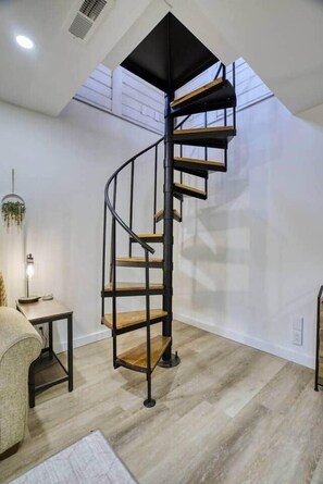 Charming spiral staircase with modern style, adding character and unique design to the space. - The Black Log Cabin - Hot Tub & Game Room (Fredericksburg)