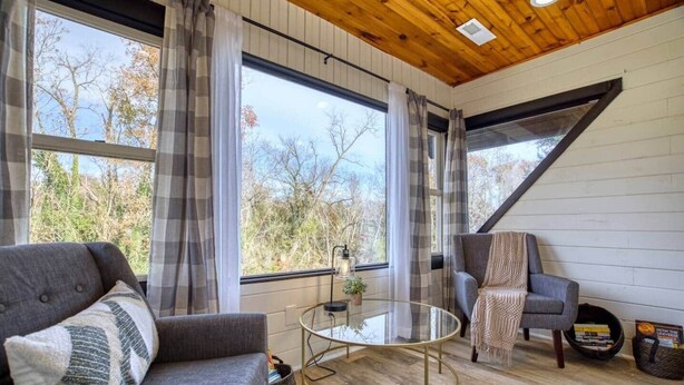 Une pièce chaleureuse avec un canapé, un fauteuil et une table basse en verre.