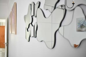 En modern inredning med abstrakt väggkonst, en trädörr och en inramad tavla.