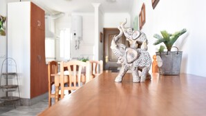 Una zona de dinar amb taula de fusta, cadires i una escultura decorativa d'elefant.
