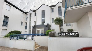 A multi-story residential building with a sign reading 'PORT CHARLY.' - Studio Emma – Sea View with Terrace (Le Croisic)