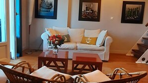 Un soggiorno con divano, tavolo da pranzo, sedie e decorazioni a parete.