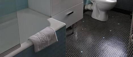 Un baño con bañera, lavabo e inodoro.