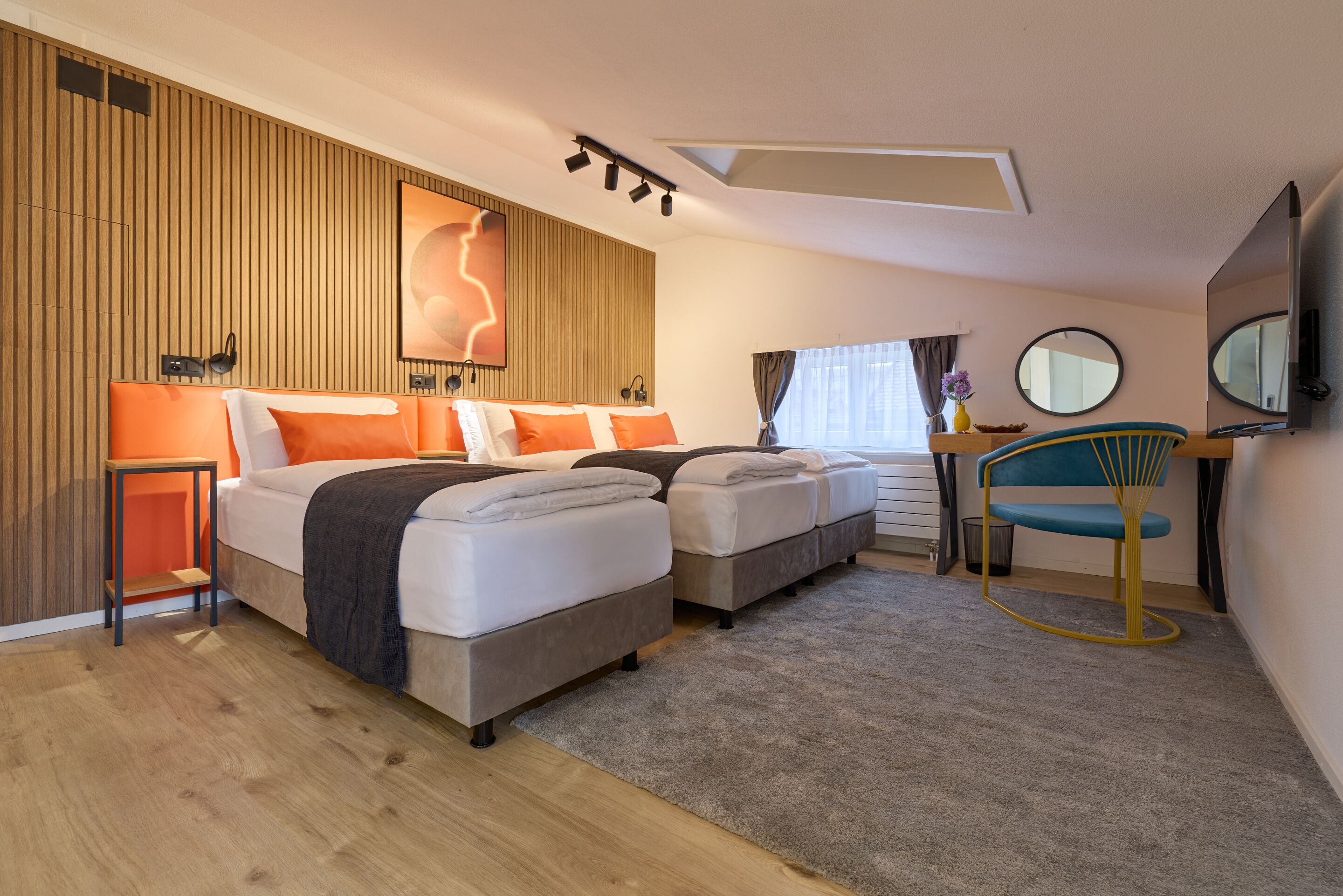 Une chambre d’hôtel moderne avec deux lits, un bureau et une chaise.