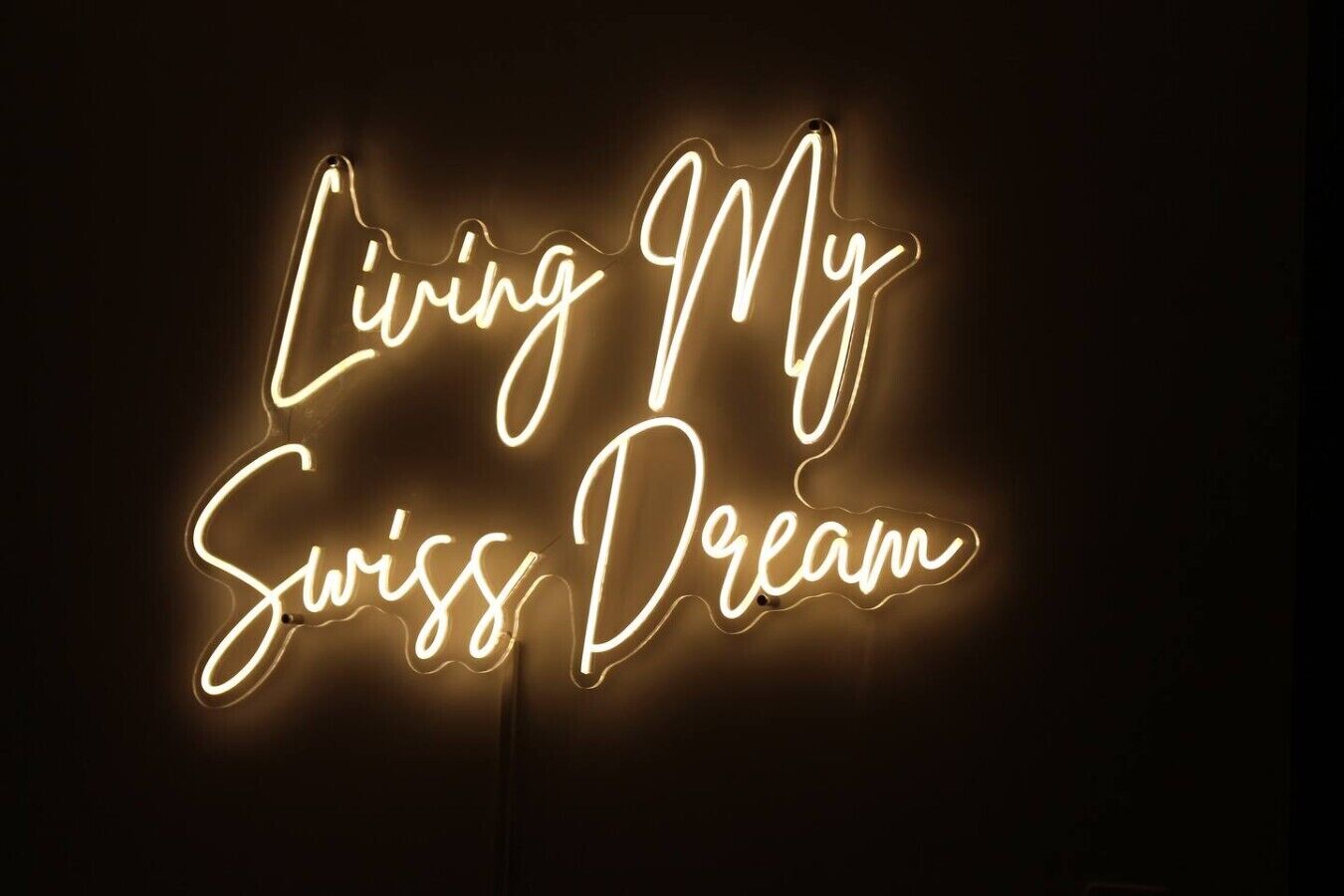 A neon sign with the text 'Living My Swiss Dream.'