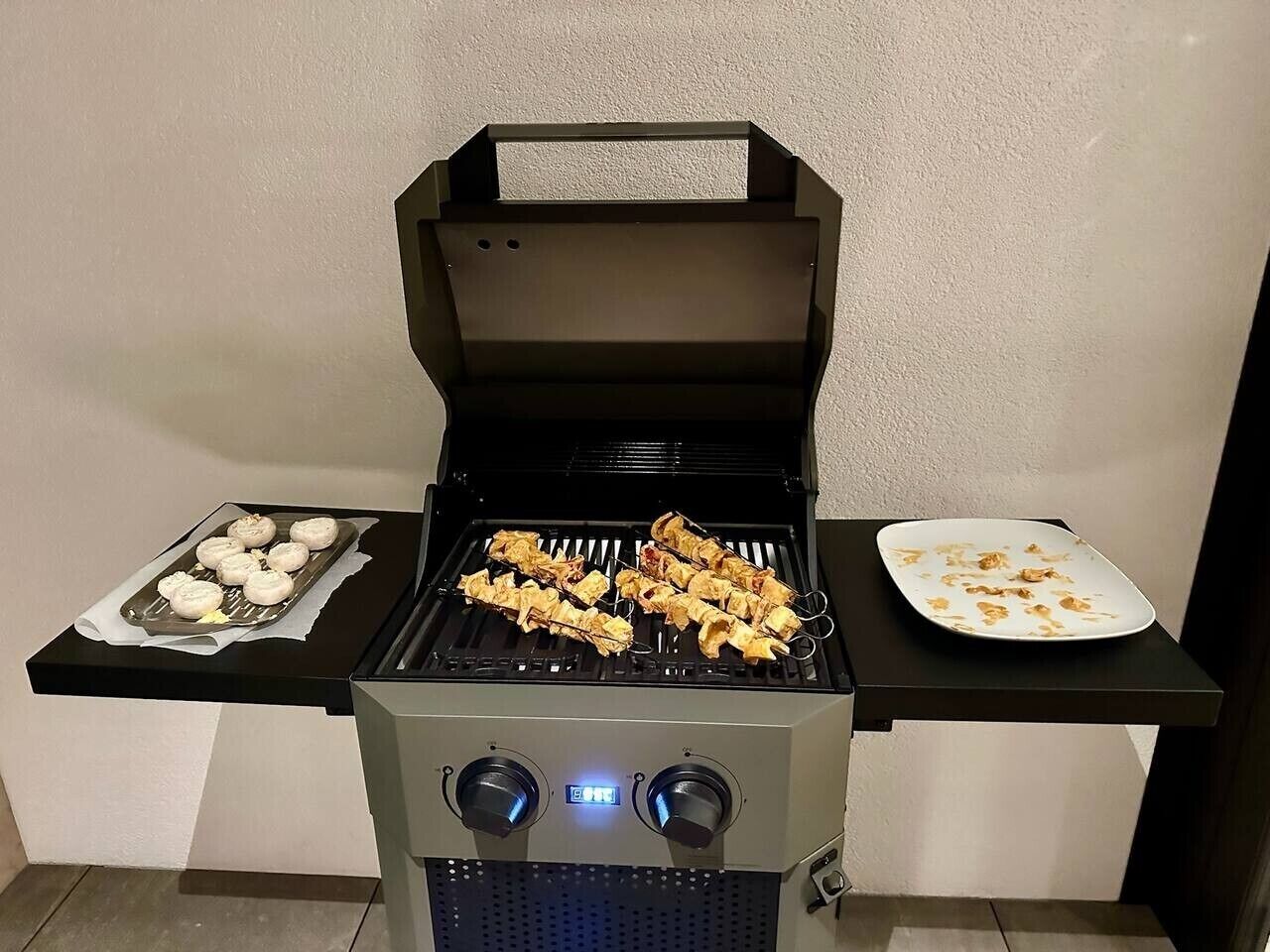 Una parrilla portátil con alimentos, una pantalla digital y un panel de control.