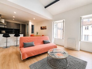 A modern apartment with a sofa, a dining table, a kitchen, and large windows. - 40 m² apartment facing the Old Port of La Rochelle (La Rochelle)