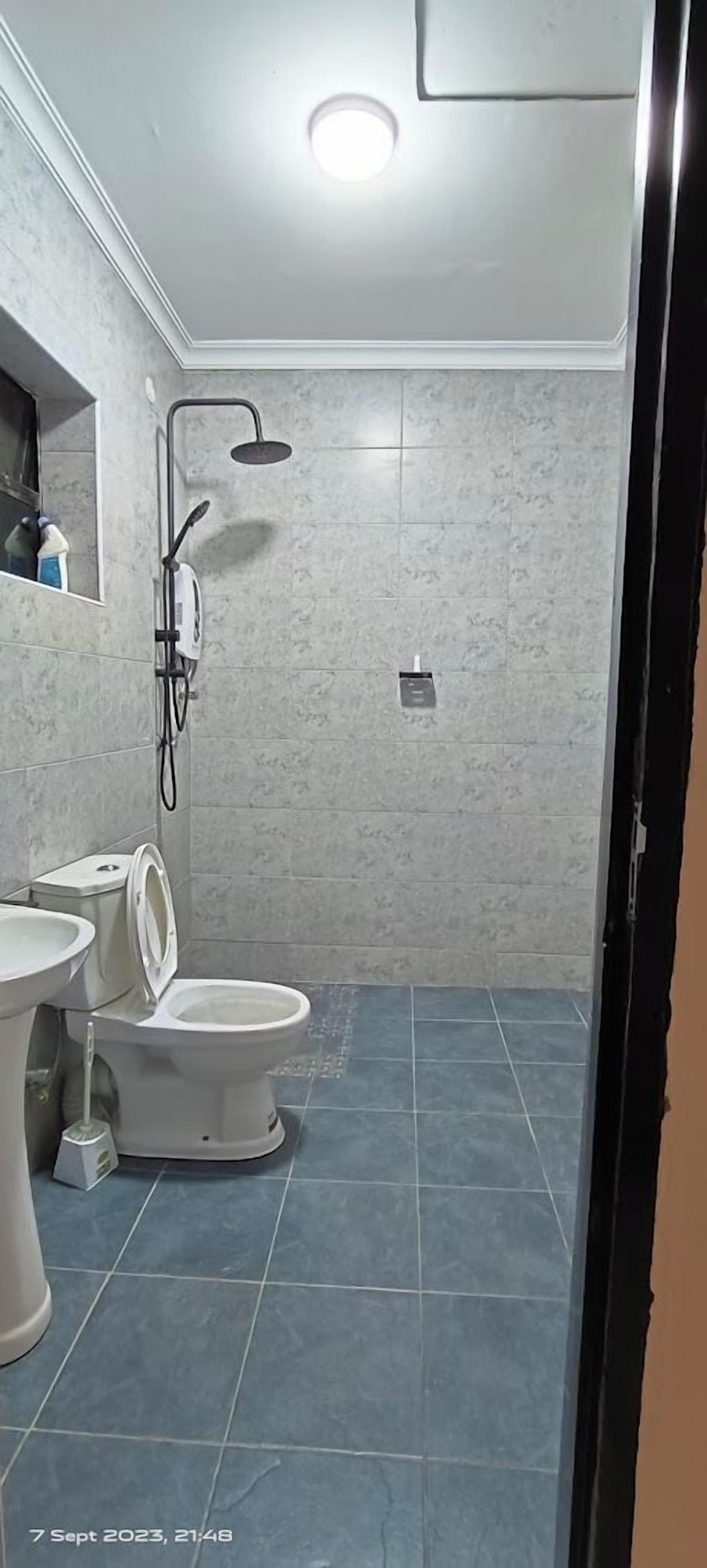 Une salle de bain équipée de toilettes, d’un bidet et d’une douche.
