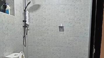 Une salle de bain équipée de toilettes, d’un bidet et d’une douche.