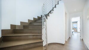 A modern staircase with a metal railing leading to a bright hallway. - Apartment 'Voramar 33A Joana Duplex' with Sea View, Private Terrace and Wi-Fi (Port Pollensa)