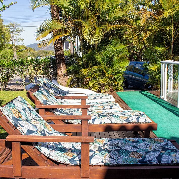 Una piscina al aire libre, sillones reclinables de piscina