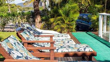 Una piscina al aire libre, sillones reclinables de piscina