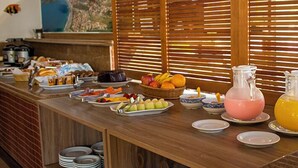 Ein Buffet mit verschiedenen Speisen, ein großes Gemälde und eine Trennwand aus Holzlamellen.