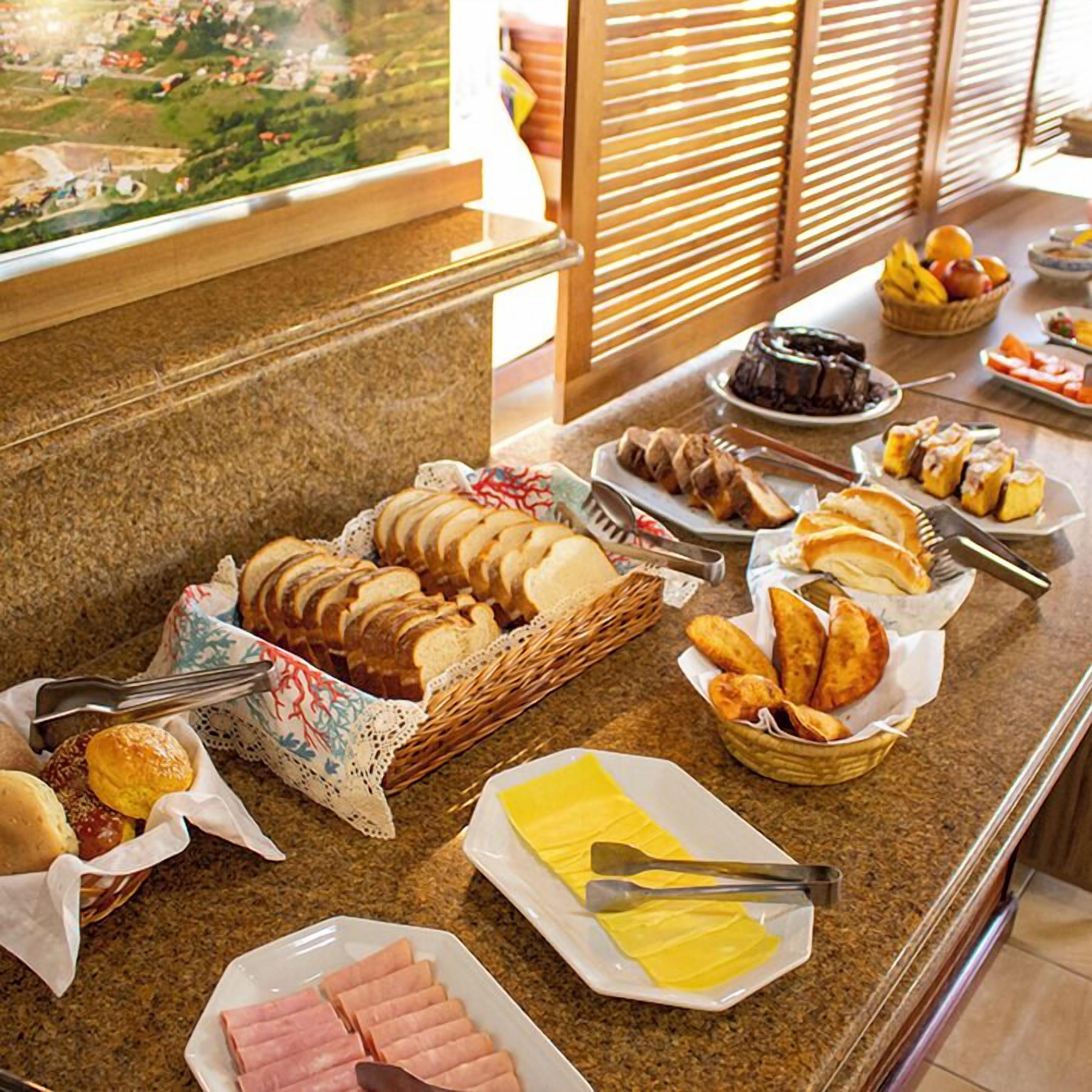 A buffet with various food items including bread, pastries, and meats.