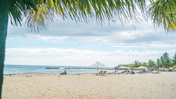 On the beach, white sand, free beach cabanas, beach umbrellas