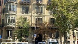 Un edificio histórico con detalles arquitectónicos ornamentales, varios balcones y una fachada clásica.