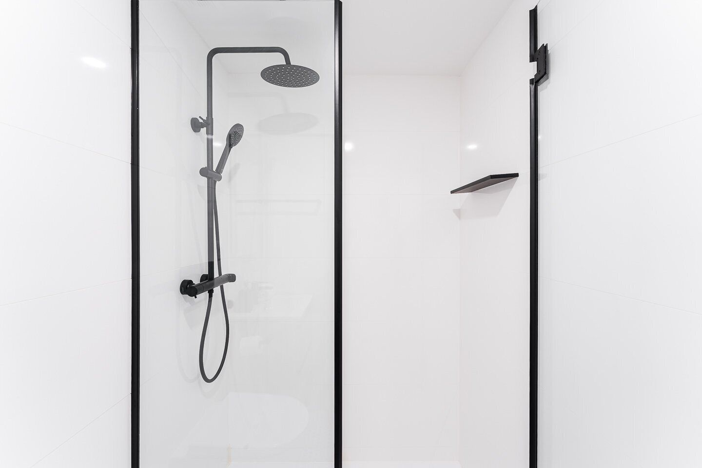 Eine moderne Dusche mit Handbrause und Regendusche.