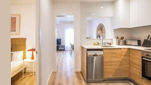 A modern kitchen with wooden cabinets, a stainless steel dishwasher, and a microwave. - 63IND1125- Brand new apartment (Barcelona)