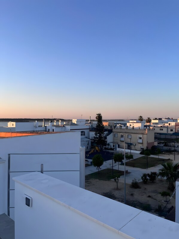 A residential area with white buildings, a playground, and a clear sky.