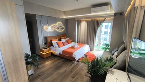 Ein modernes Hotelzimmer mit einem großen Bett, einem Fernseher und einem Balkon mit Blick auf die Stadt.