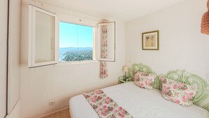 A bedroom with a bed, a window, and a framed picture on the wall. - Boulouris Panorama - Vue sur la Mer (Saint Raphael)
