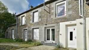 Un bâtiment en pierre doté de nombreuses fenêtres et portes, dont une porte portant le numéro 19.