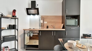 Une cuisine compacte équipée d’un four à micro-ondes, d’un grille-pain et d’un petit évier.