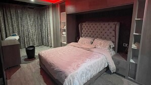 Une chambre à coucher moderne avec un grand lit, une armoire intégrée et une coiffeuse avec un miroir.