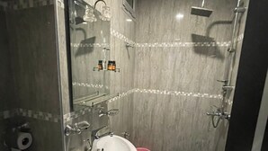 Une petite salle de bain comprenant un lavabo, des toilettes et une douche.