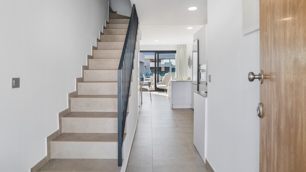Een modern interieur met een trap die naar een eethoek leidt.