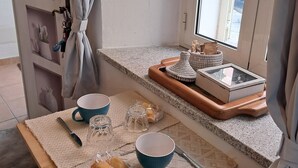 Un angolo cottura con un piano di lavoro, una finestra e una porta.