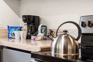 A kitchen with a coffee maker, a kettle, and some packaged food items on the counter. - Prime location • Private pool & BBQ (Noord)