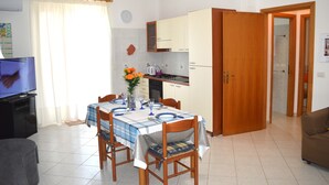 Um espaço compacto com área de refeições, cozinha compacta e televisão.