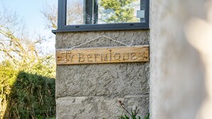 Een houten bord met de naam 'Bernardo' bevestigd aan een structuurrijke muur.