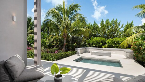 A modern outdoor pool area with a seating arrangement and lush greenery in the background. - Spacious Room w/ Sea Views + Modern Elegance – Perfect for Relaxing Retreat (Long Bay Hills)