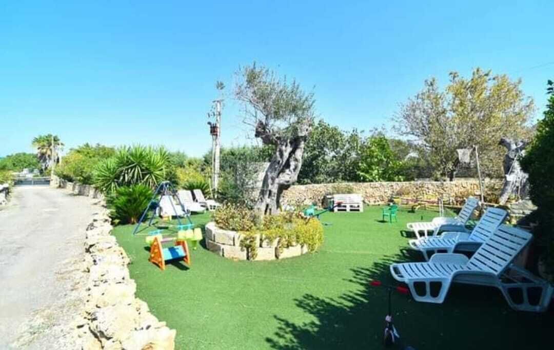 A garden area with outdoor seating, a small play structure, and a stone wall.