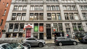 Un edifici de diversos pisos amb diferents comerços, com ara un centre de massatge, un restaurant indi i un tatuatge.