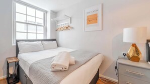 A modern bedroom with a large bed, a bedside table, a lamp, and a window. - Host Stay Apartment 10 Stanley Street (Liverpool)