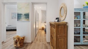 A hallway with a wooden floor, a dog in a basket, a mirror, and a cabinet with dishes. - Apartment '5 Terre - Lerici - La Caletta' with Sea View, Wi-Fi and Air Conditioning (Lerici)