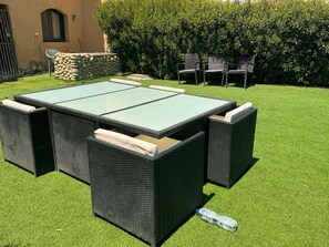 A patio with a glass-top table and wicker chairs. - EXORA SPARK LA HACIENDA RAS SEDR VILLA (South sinai Governorate)