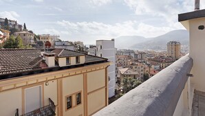 Stadtbild mit Gebäuden, blauem Himmel und Bergen in der Ferne.