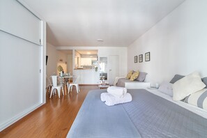 A modern hotel room with a large bed, a dining area, and a kitchenette. - Charming studio on Las Heras Avenue, Recoleta | 4P (Ciudad Autónoma de Buenos Aires)
