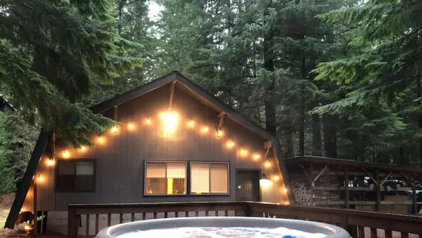 A cabin with a hot tub in front, surrounded by trees. - Serene 1-bedroom cabin in charming Ashford perfect for getaway (Ashford)