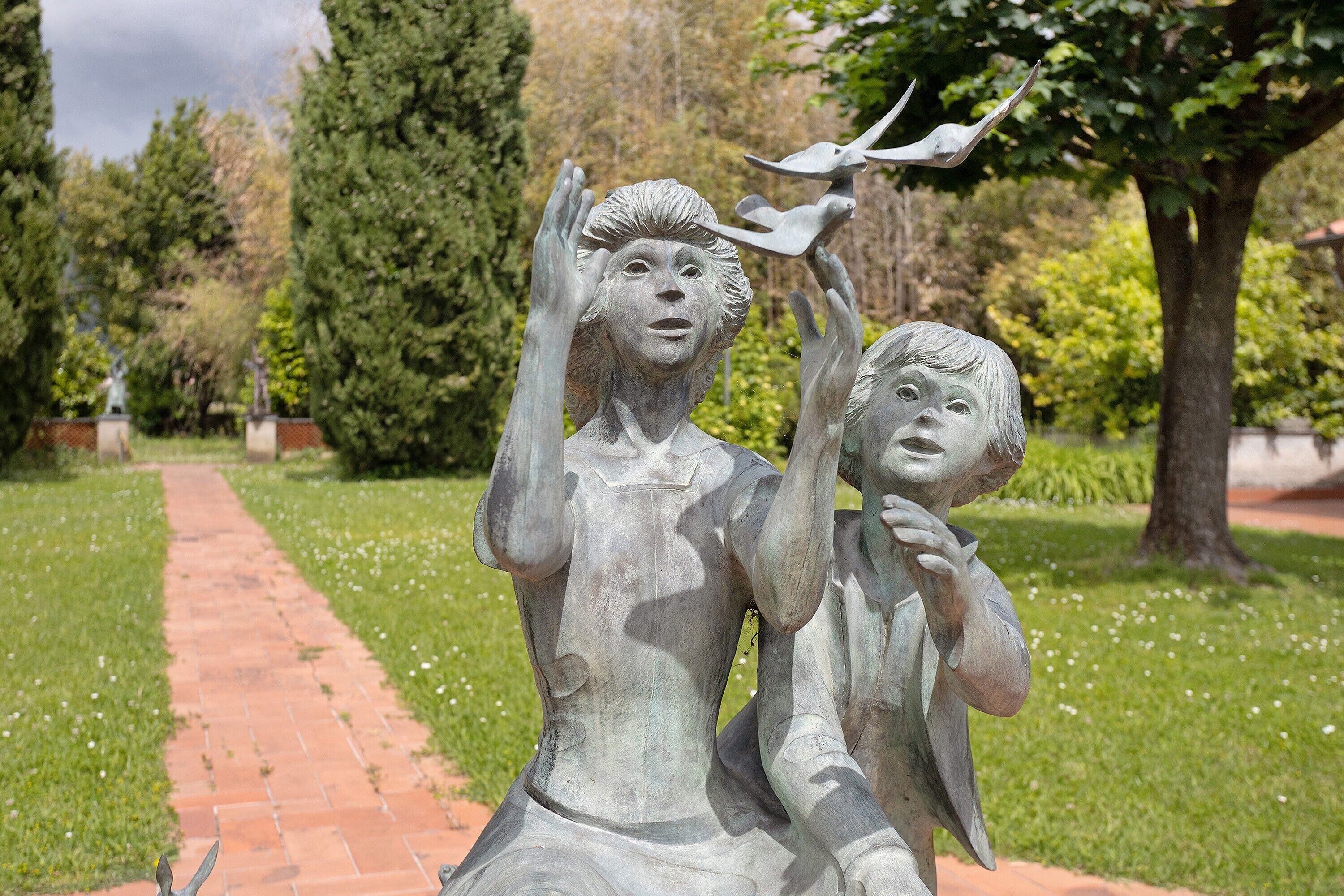 A statue of two figures with one holding a bird.